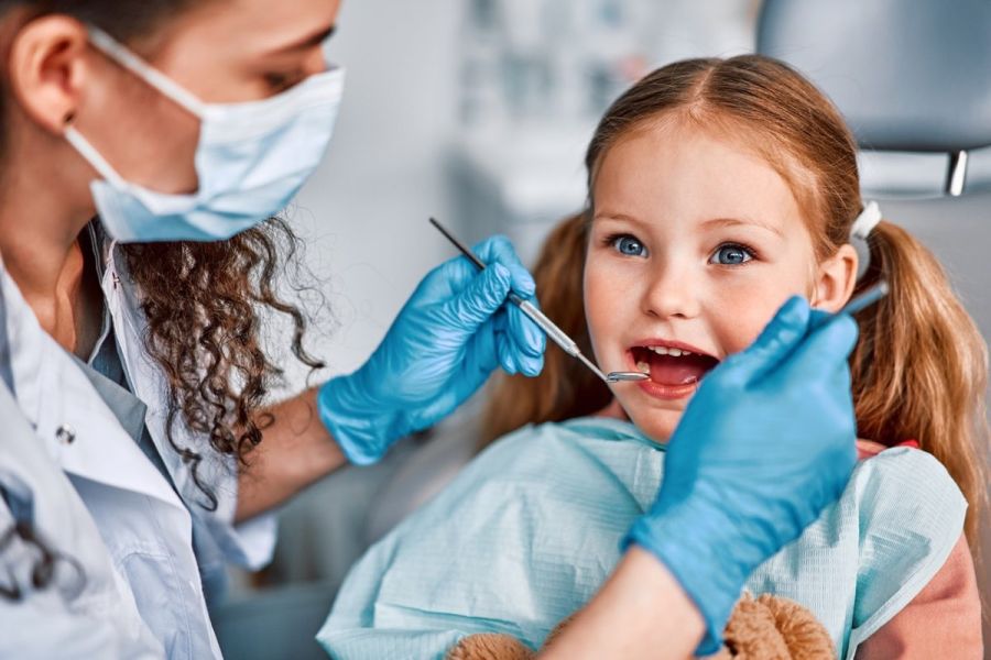 At the doctor’s appointment. Portrait of a child being examined by a dentist.