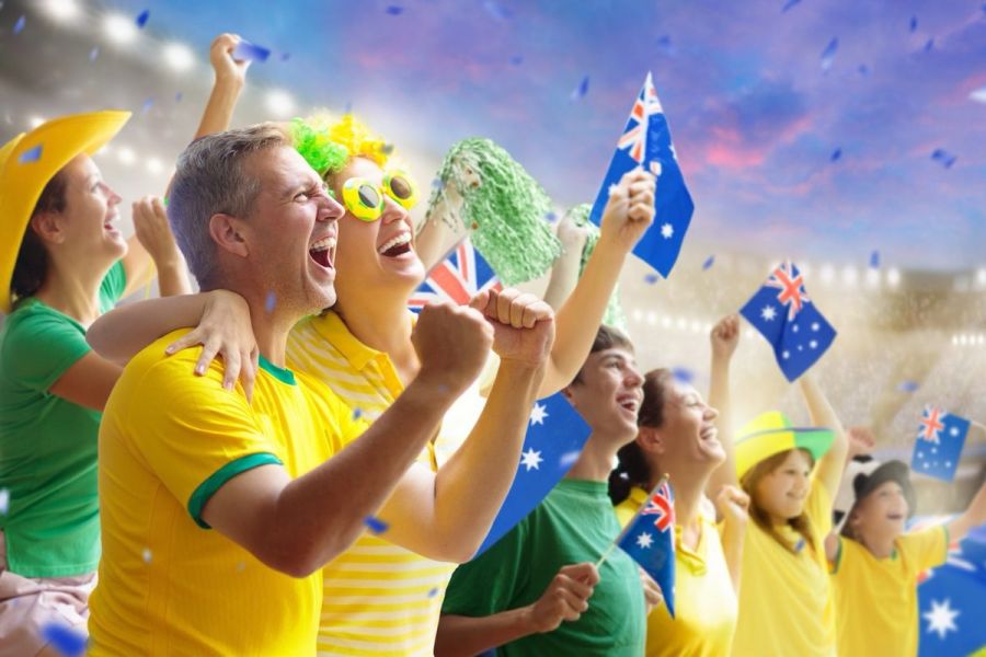Australia fans on stadium. Australian supporters. Crowd cheering for Aussie football or cricket team victory. Soccer match on outdoor pitch. Patriotic party with national flag and jersey.